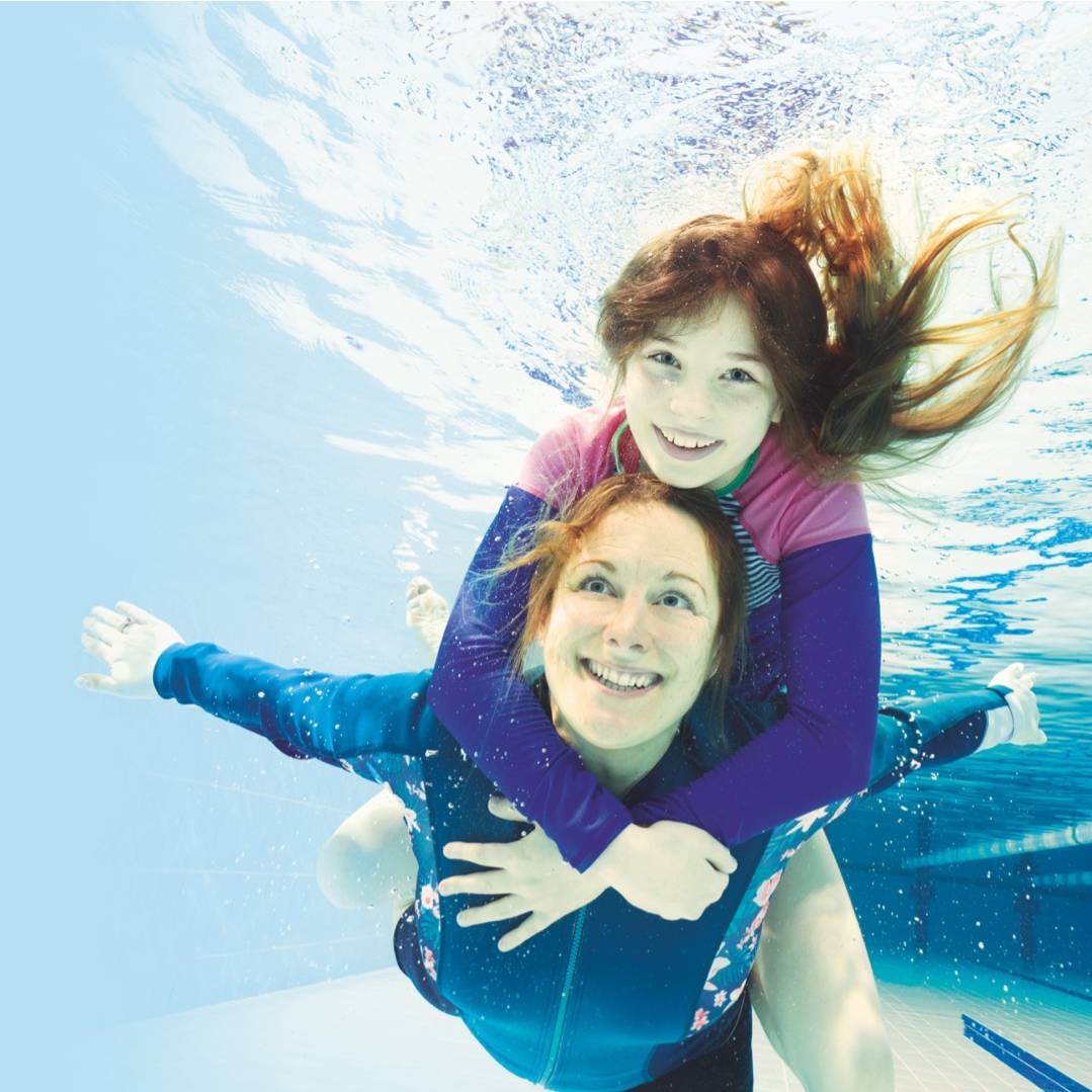 mother and girl under water