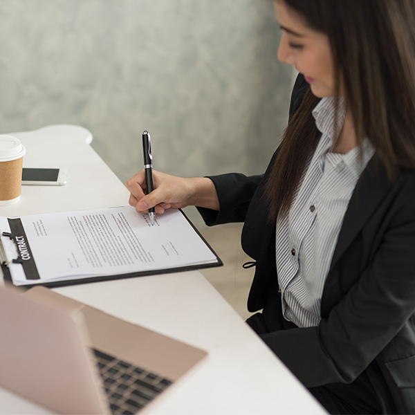 Professional signing documents at a desk