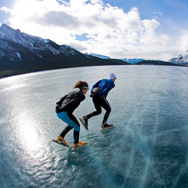 two people skating on a frozen lake