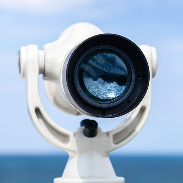 White telescope stands on sea coast