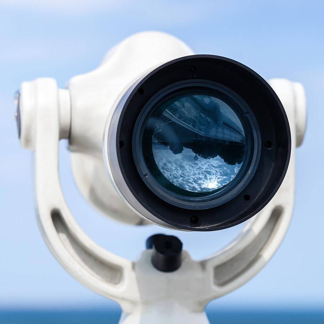 White telescope stands on sea coast