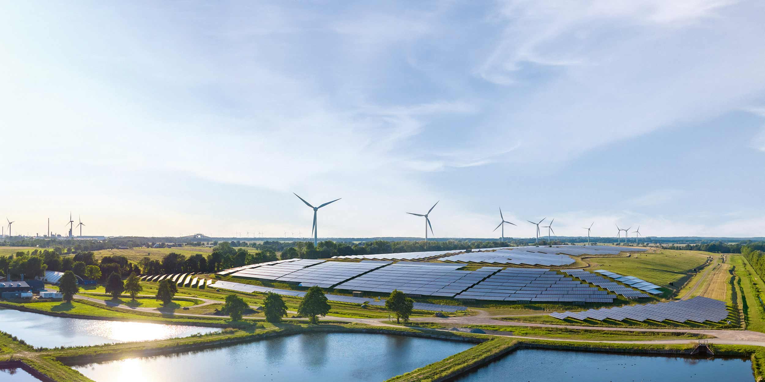 area with solar panels, wind turbines and water