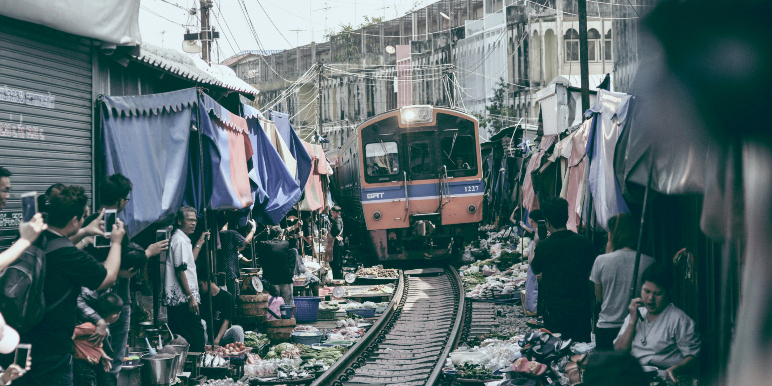 A train enters a crowded city suburb