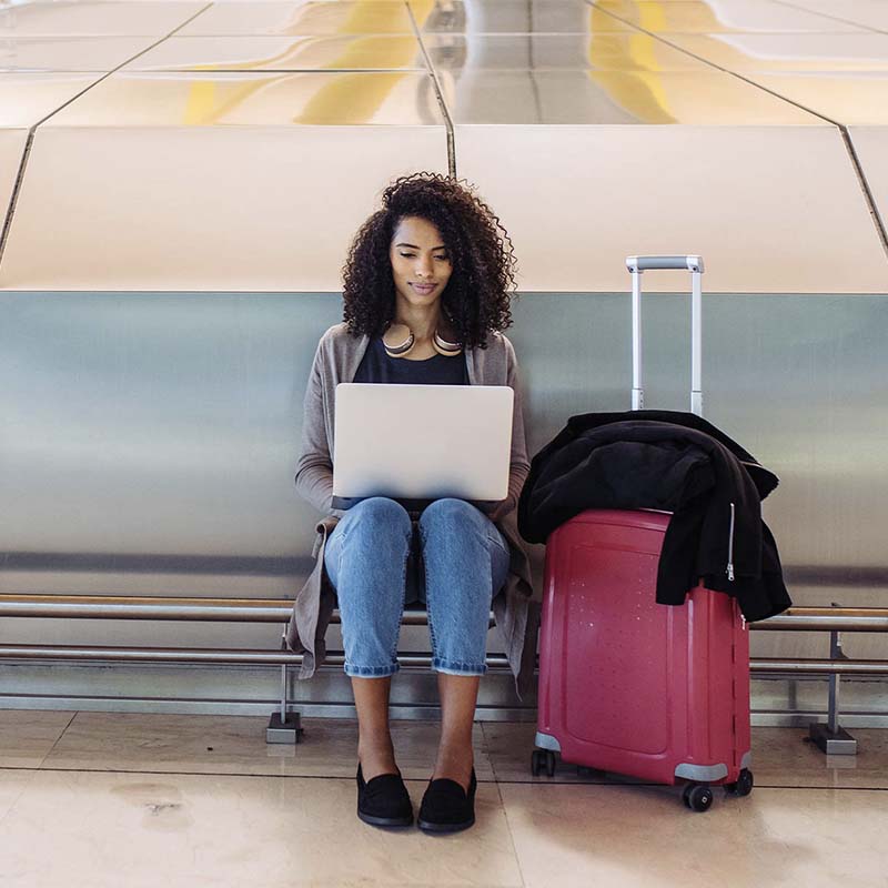woman sitting with suitcase at airport
