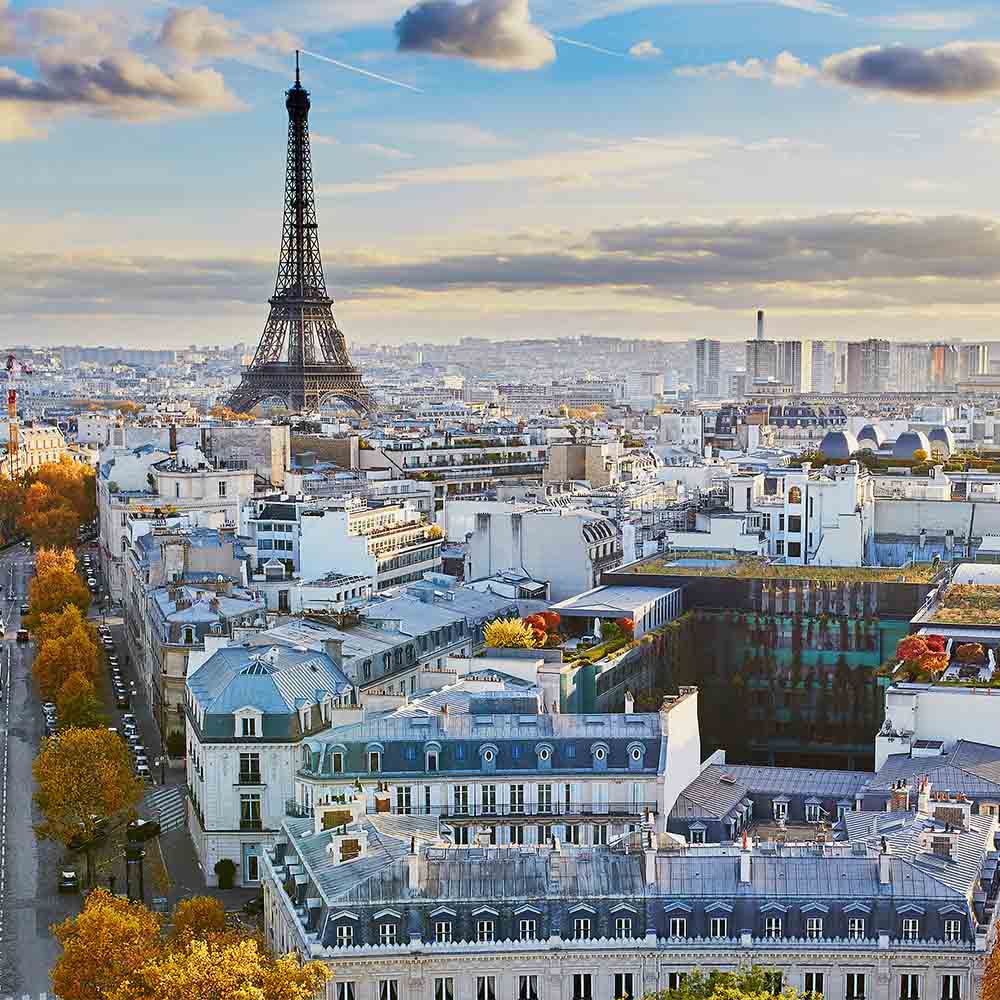 View of Paris with the Eiffel Tower rising above the city skyline in warm afternoon light