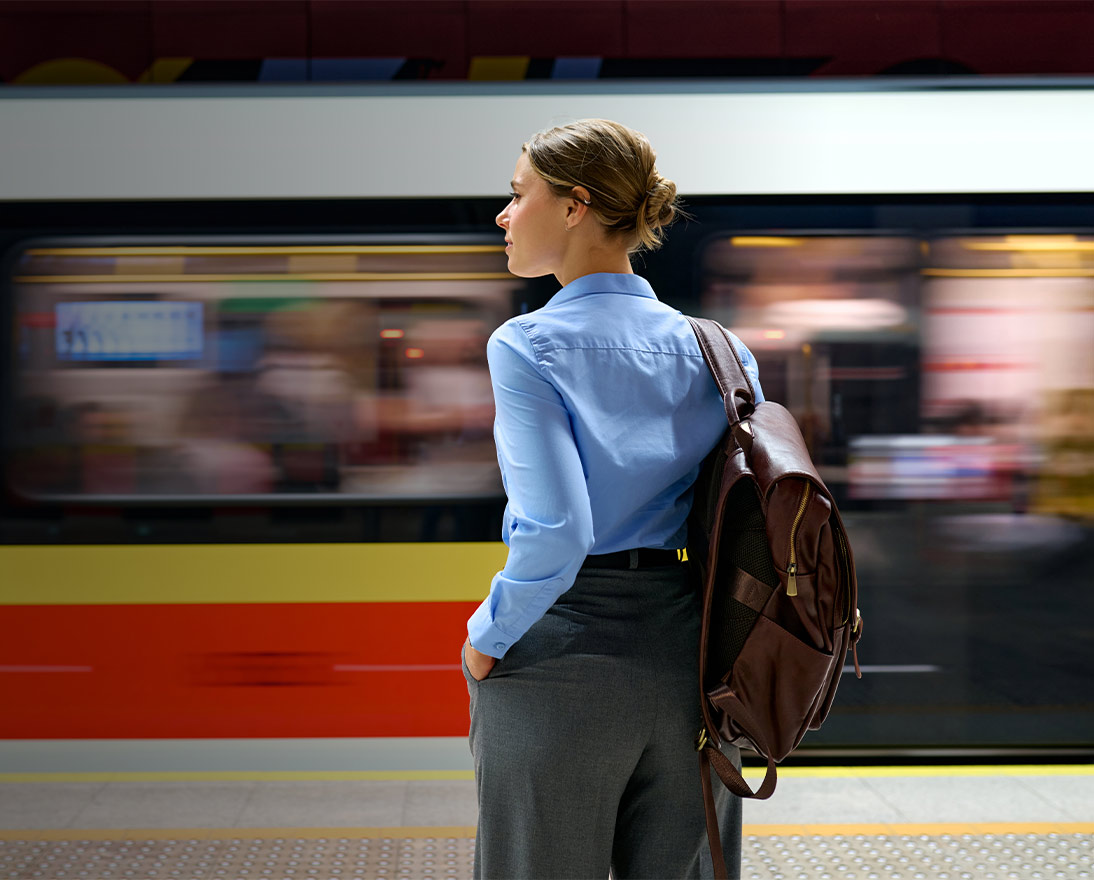 Woman standing on a platform at a train station watching a train go by