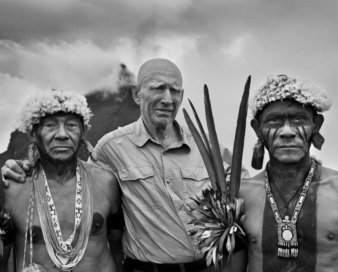 Sebastião Salgado with Yanomami indigenous people in the Amazon in 2014, with Brazil’s highest peak, Pico da Neblina, in the background. © Sebastião Salgado. All rights reserved