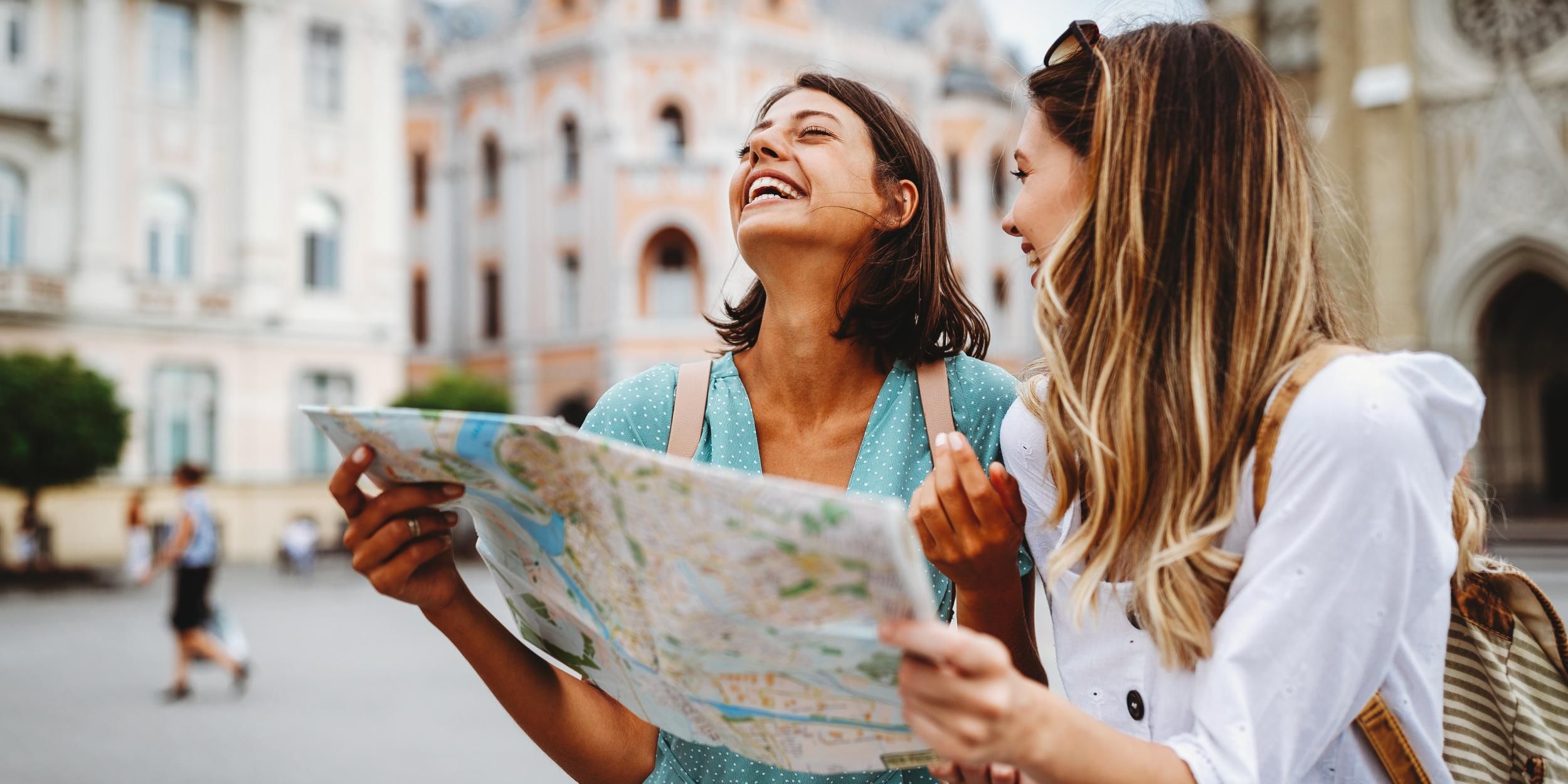 two people holding map in european city