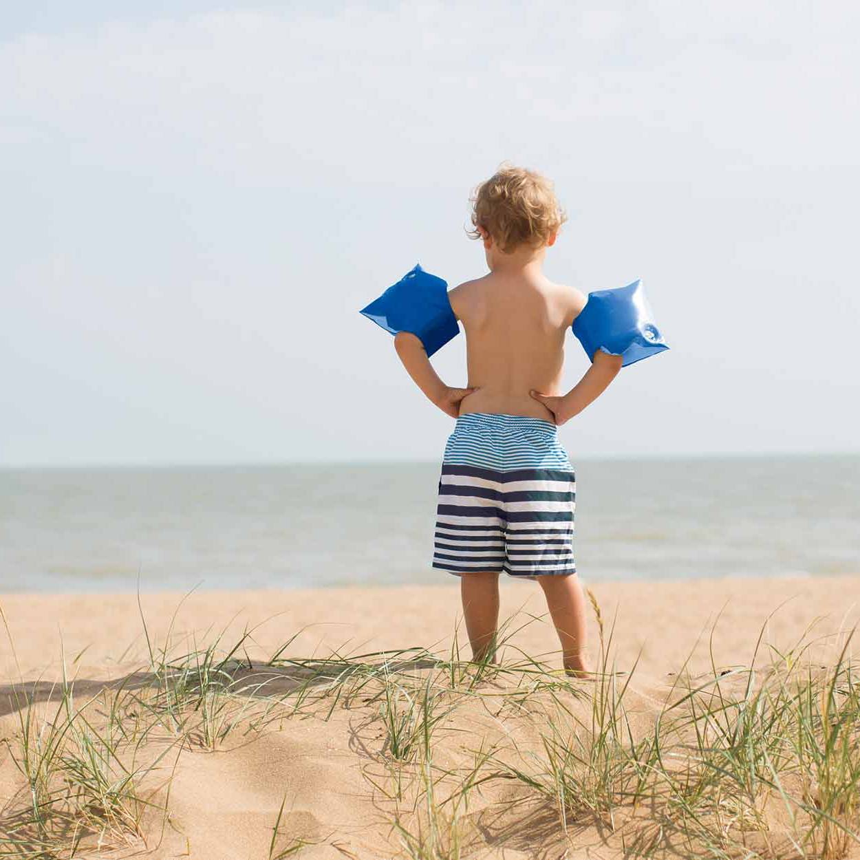 Boy on beach wearing blue armbands Boy on beach wearing blue armbands