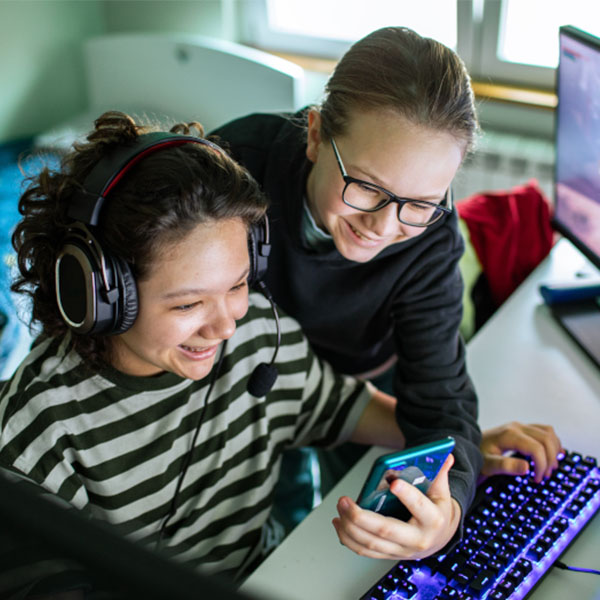 Two people using digital devices and collaborating at a computer workstation