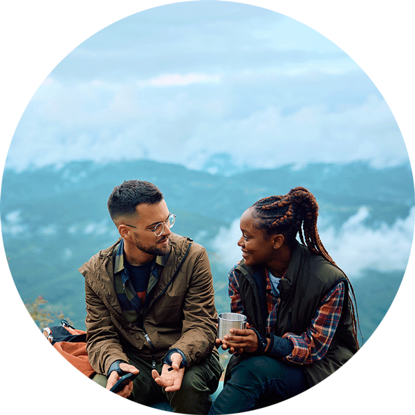 adventurous couple talk while relaxing father hiking in mountains