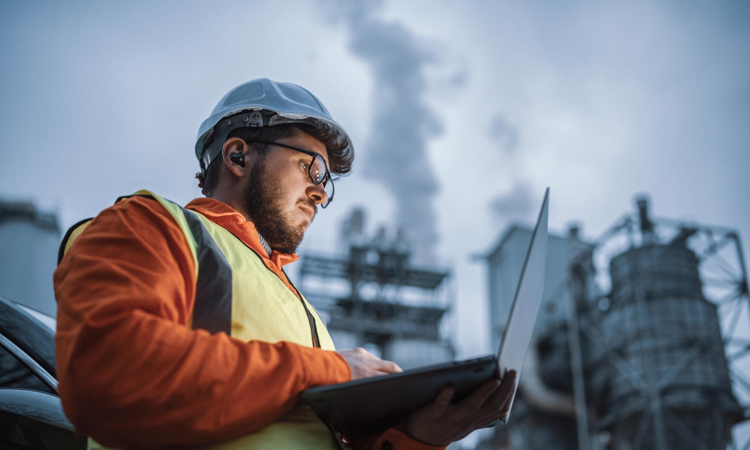 An engineer using a laptop while working in the oil and gas industry