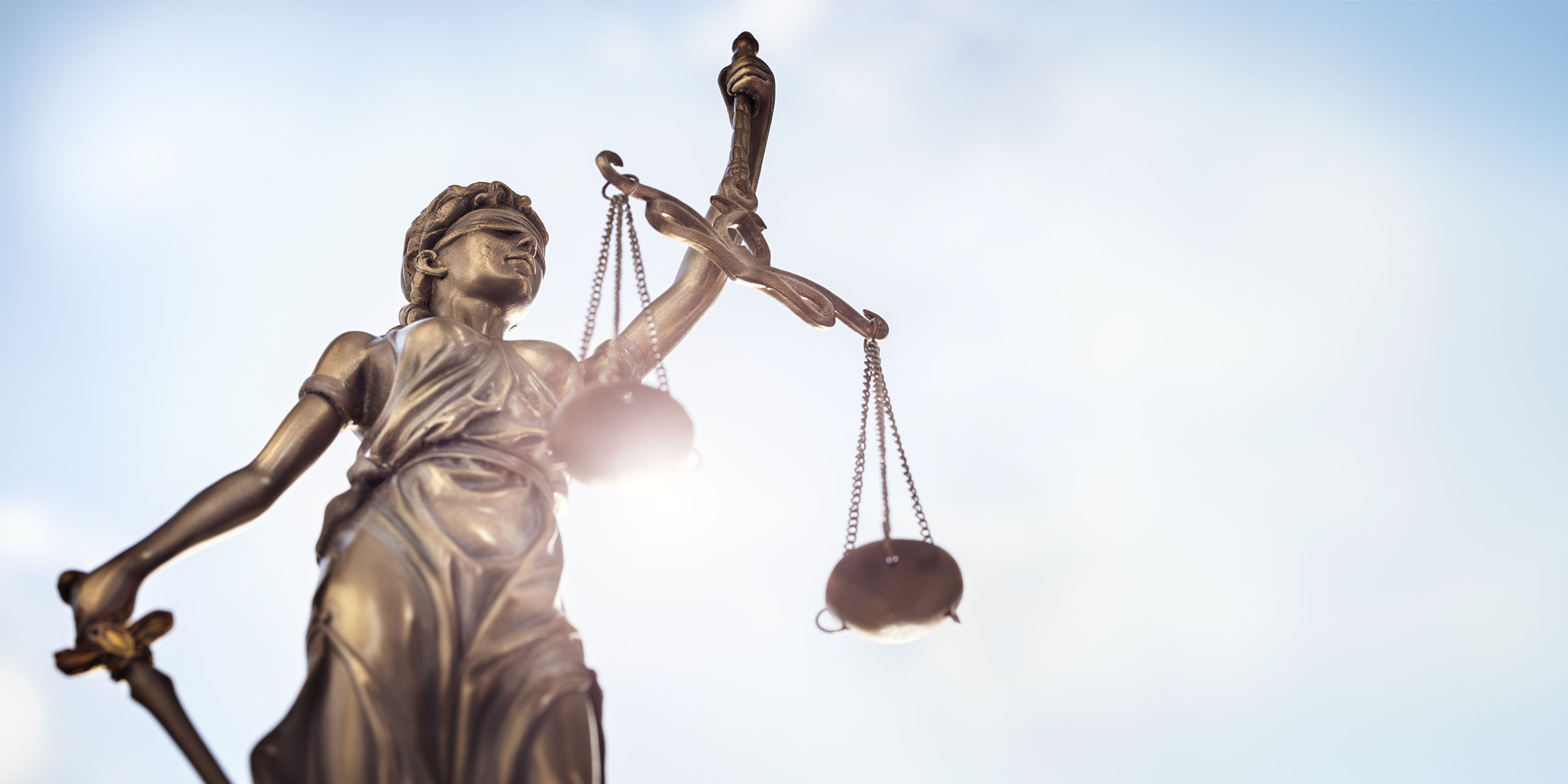 Legal law concept statue of Lady Justice with scales of justice sky background