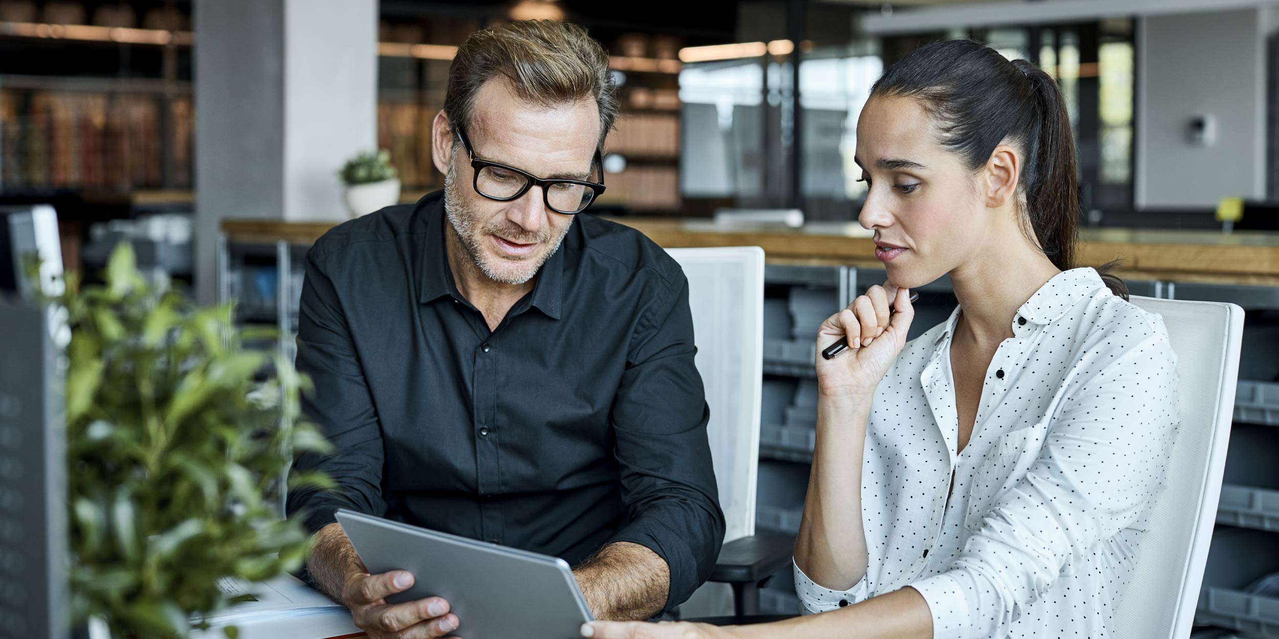 Male and female colleagues looking at tablet
