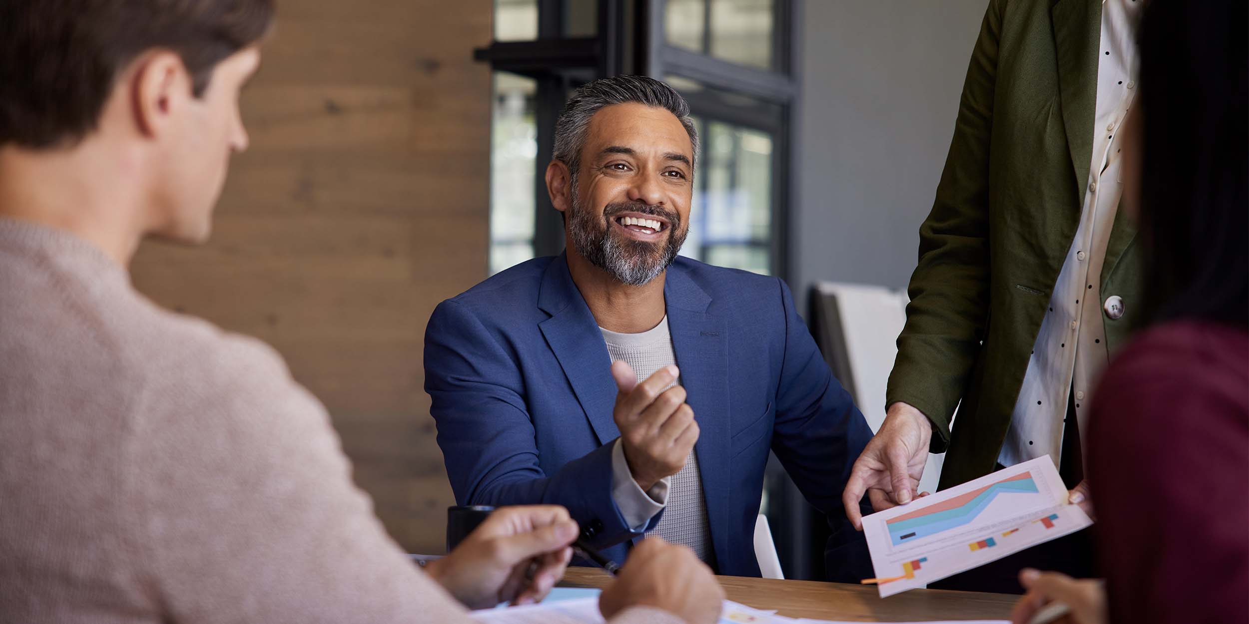Team members discussing business insights and reviewing charts during a meeting