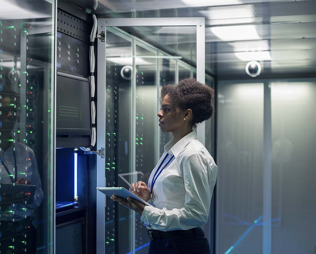 Female technician works on a tablet in a data center