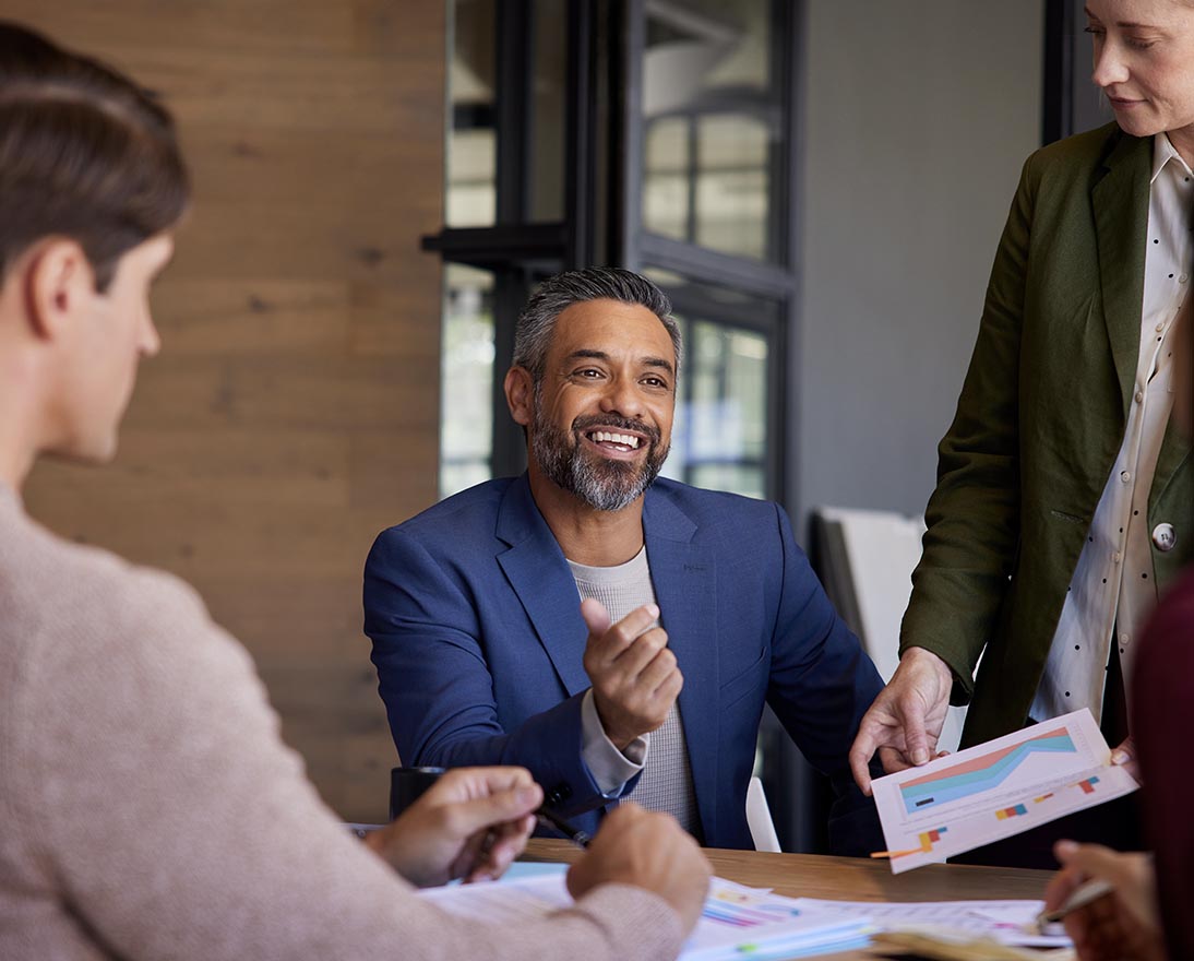 Team members discussing business insights and reviewing charts during a meeting