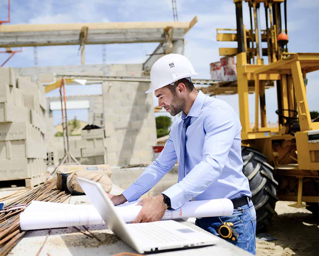 Construction site professional reviewing building plans and project details