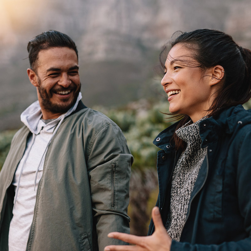Happy young couple walking and talking in the countryside