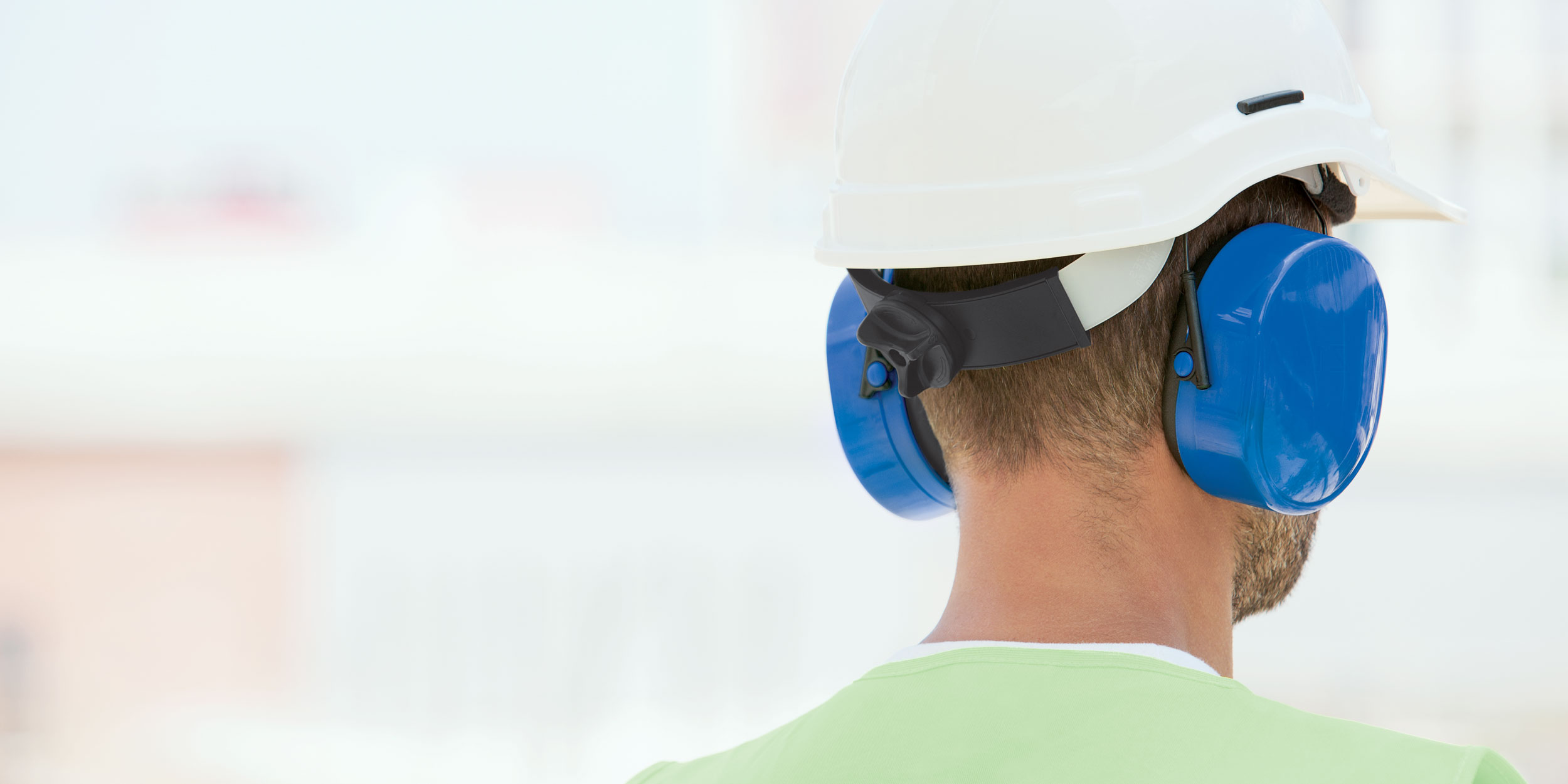 Man wearing safety helmet and ear defenders