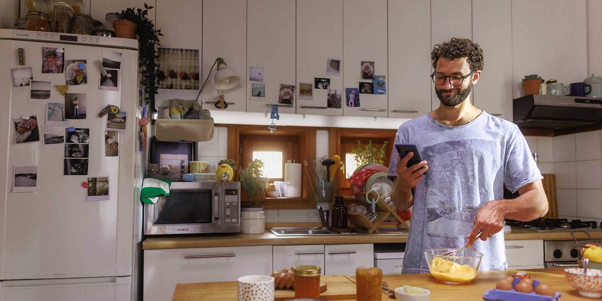 man checking phone while cooking