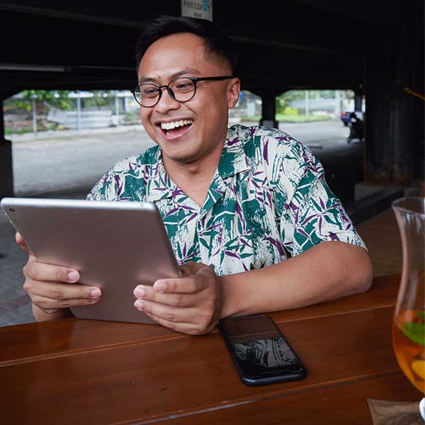 man with tablet laughing