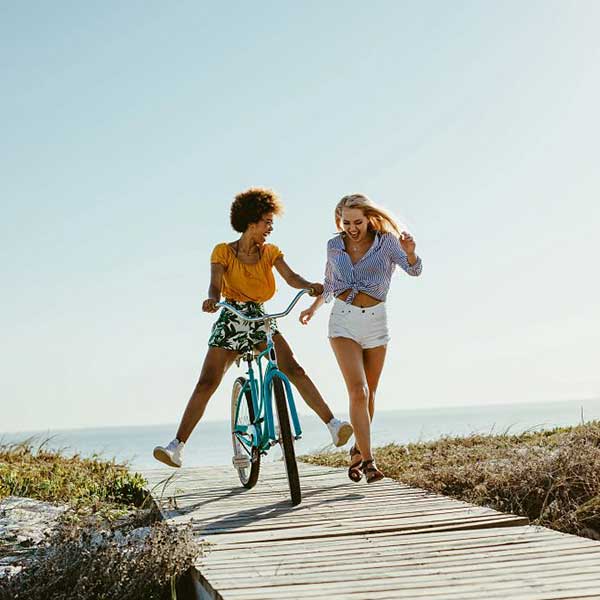 women with a bike at beach