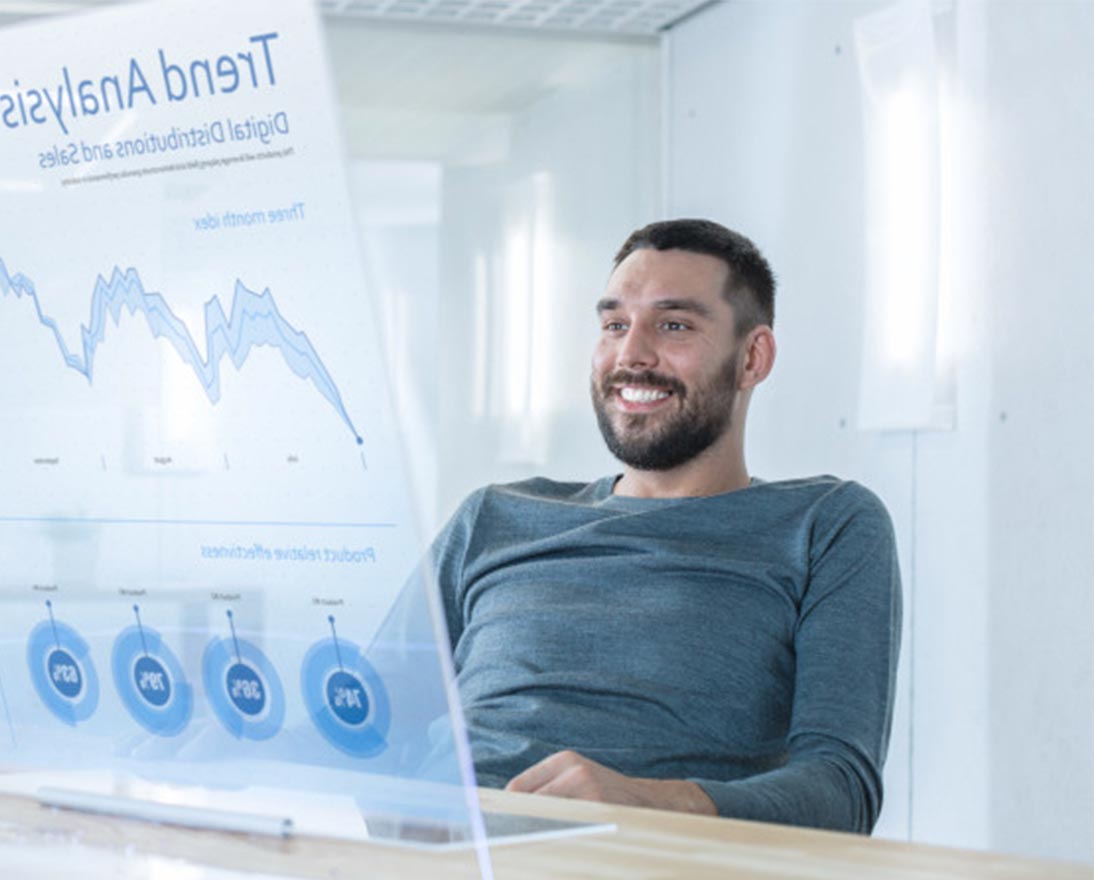 man smiling and looking at graphs