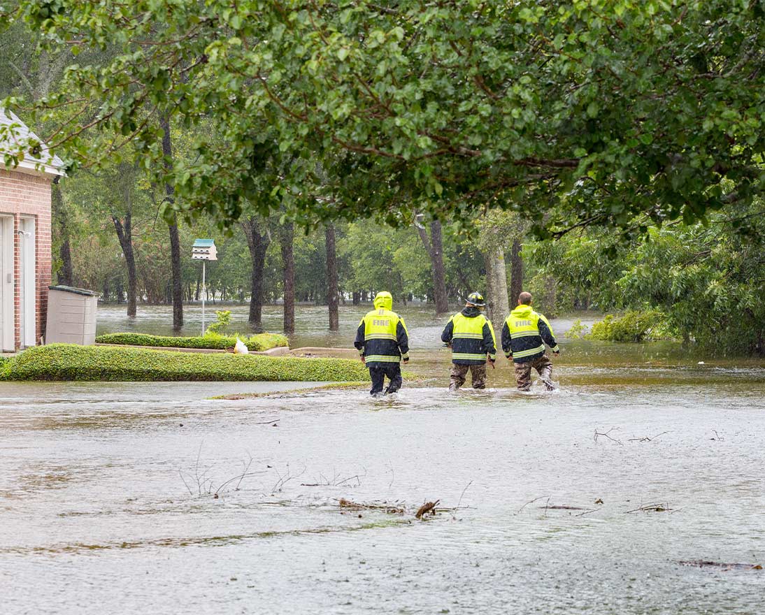 fire fighters walking through flooding