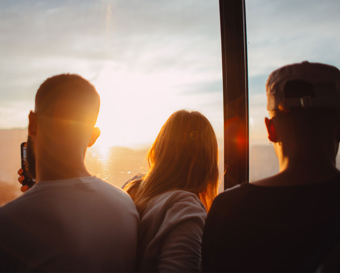 three people looking at a sunset 