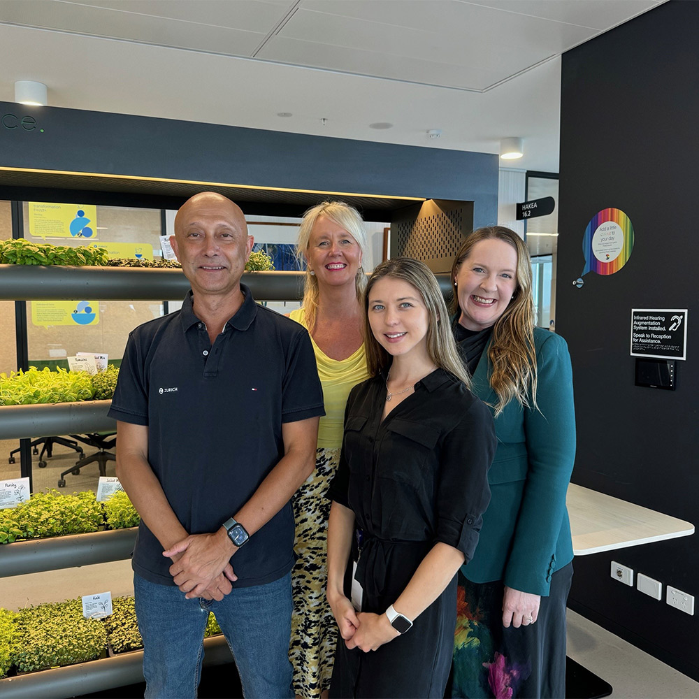 Zurich employees standing in front of the microfarm at the office