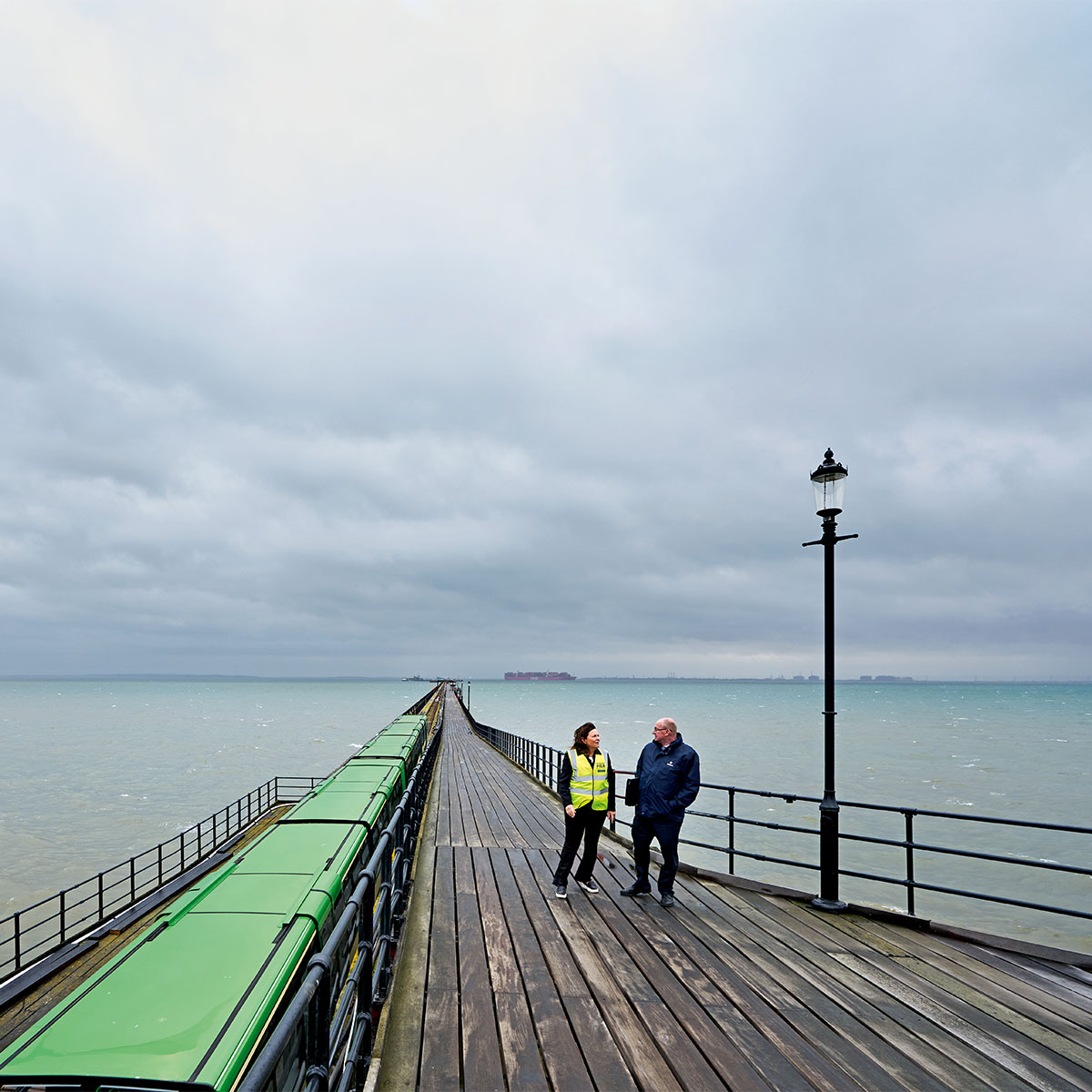 Two people standing on a pier