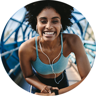 woman smiling and listening to music while running