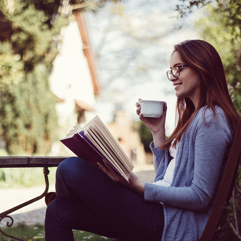 Woman drinking tea and reading a book
