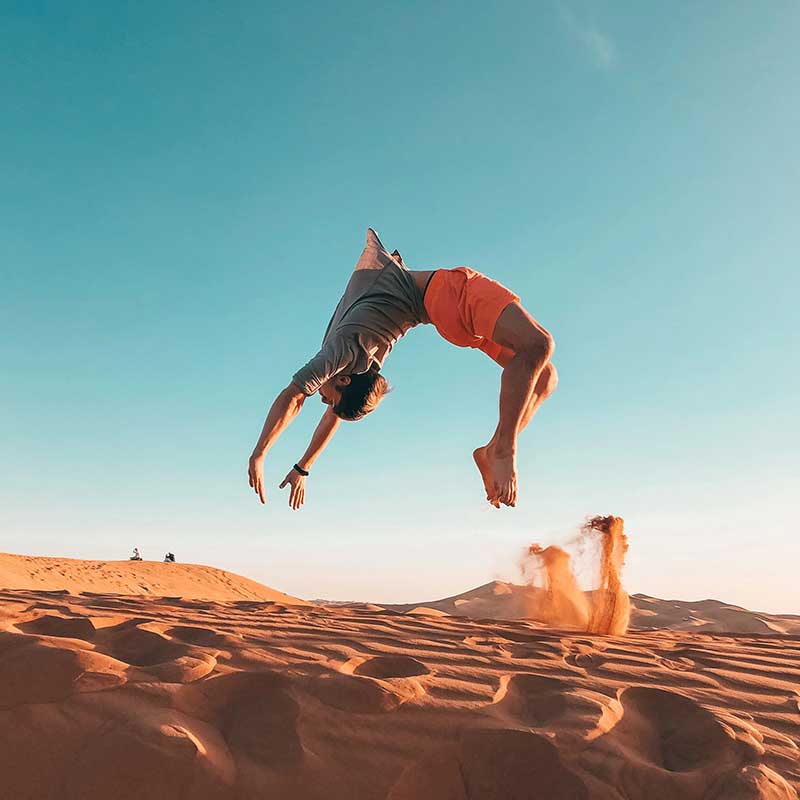 man doing a backflip in the desert