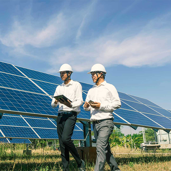 two men walking by solar panels